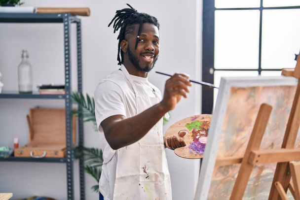 Африканська американка, усміхаючись, впевнено малює на художній студії. - Фото, зображення