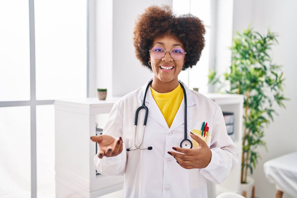 African american woman wearing doctor uniform speaking at clinic - Foto, imagen