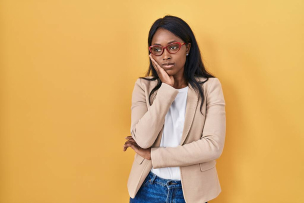 Mujer joven africana con gafas pensando que se ve cansada y aburrida con problemas de depresión con los brazos cruzados.  - Foto, Imagen