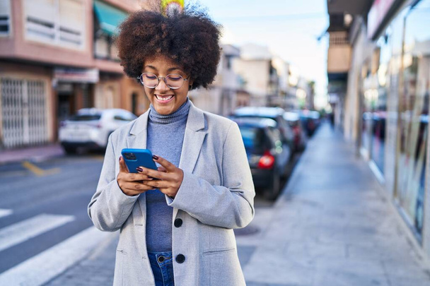 donna afroamericana esecutivo sorridente fiducioso utilizzando smartphone in strada - Foto, immagini