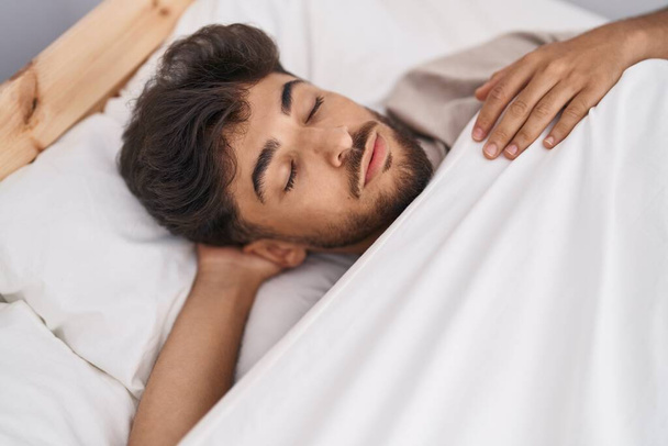 młody arabski człowiek leżący na łóżku śpiący w sypialni - Zdjęcie, obraz