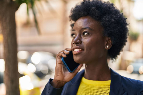 Young african american woman business executive talking on the smartphone at street - Photo, image