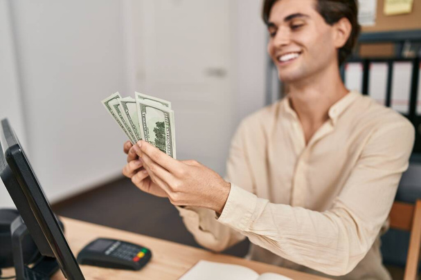 Young caucasian man ecommerce business worker counting dollars at office - Foto, imagen