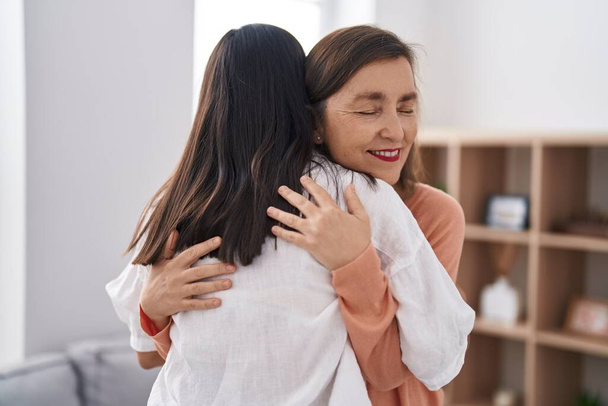 Two women mother and daughter smiling confident hugging each other at home - Foto, Imagen
