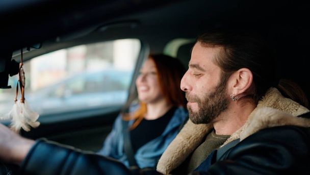 mężczyzna i kobieta para uśmiechając pewny siebie jazdy samochodem na ulicy - Zdjęcie, obraz