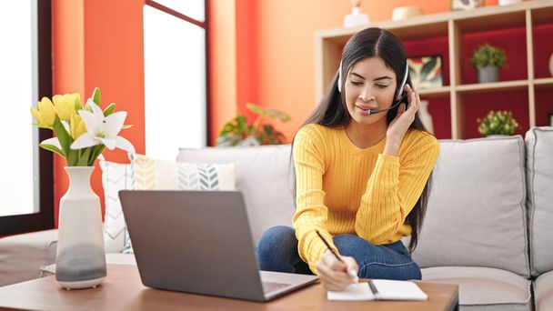 Young beautiful hispanic woman call center agent having distance working at home - Фото, зображення