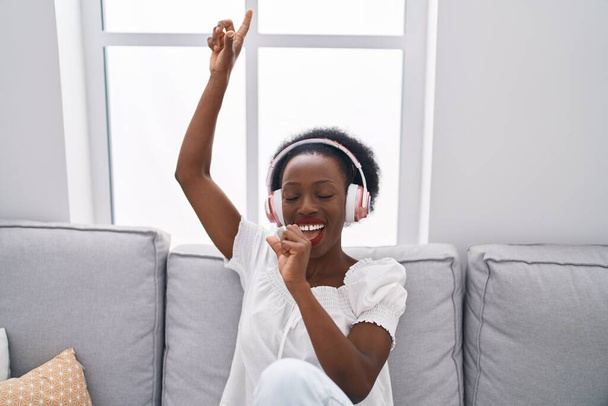 Afrikkalainen amerikkalainen nainen kuuntelee musiikkia laulaa laulun kotona - Valokuva, kuva
