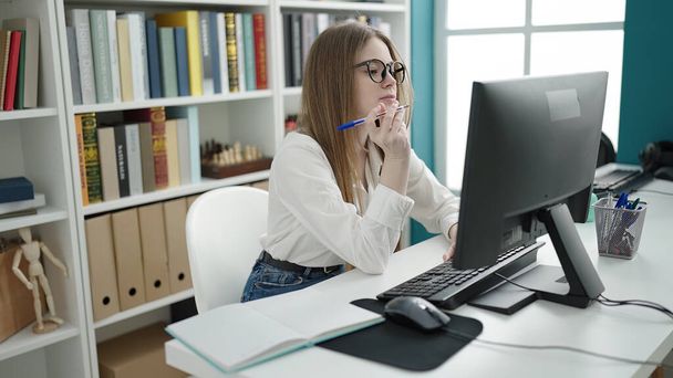 Junge blonde Studentin nutzt Computer im Hörsaal der Universität - Foto, Bild