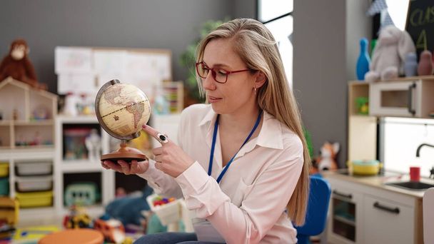 Young blonde woman preschool teacher having geography lesson at kindergarten - Photo, image