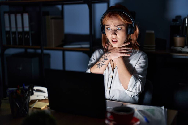 Young caucasian woman working at the office at night shouting and suffocate because painful strangle. health problem. asphyxiate and suicide concept.  - Foto, Imagen