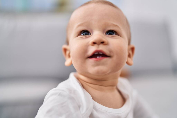 Очаровательный малыш улыбается уверенно стоя дома - Фото, изображение