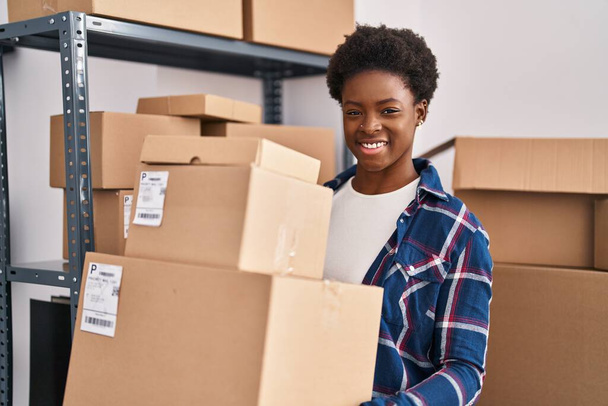 African american woman ecommerce business worker holding packages at office - Foto, Bild