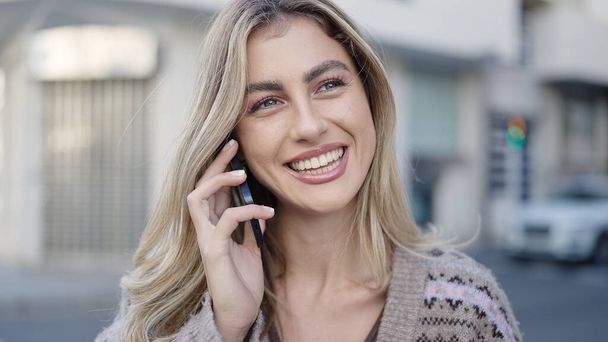 Young blonde woman smiling confident talking on the smartphone at street - Foto, immagini