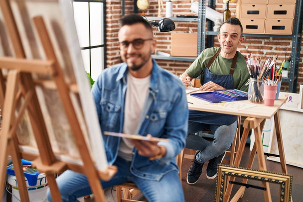 Δύο άνδρες καλλιτέχνες χαμογελώντας αυτοπεποίθηση σχέδιο στο στούντιο τέχνης - Φωτογραφία, εικόνα