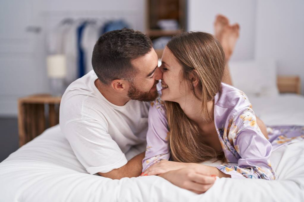 Man and woman couple lying on bed kissing at bedroom - Fotó, kép