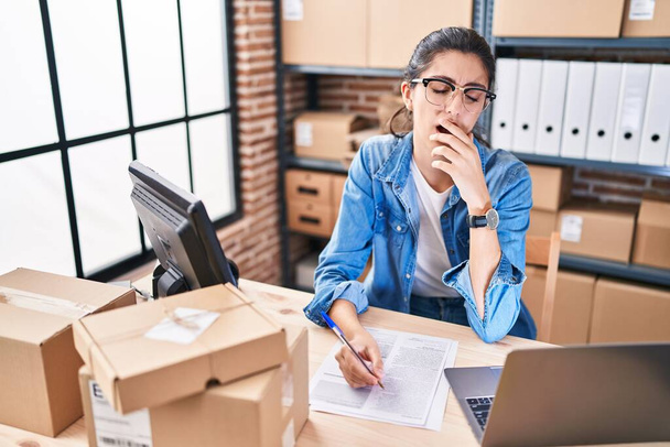 Junge schöne hispanische Frau E-Commerce-Unternehmer müde Arbeit im Büro - Foto, Bild