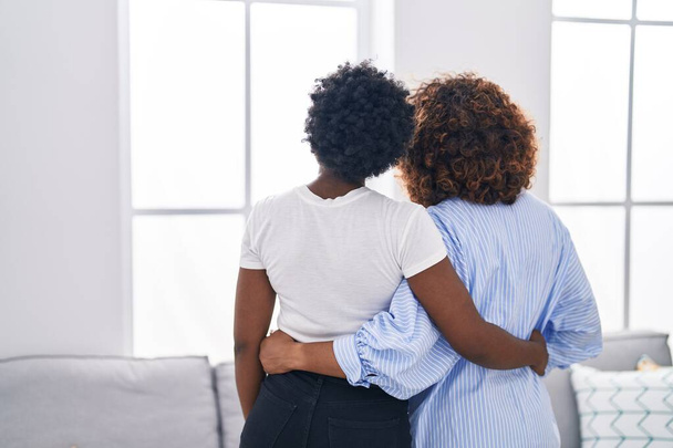 Mujeres afroamericanas madre e hija abrazándose en casa - Foto, imagen