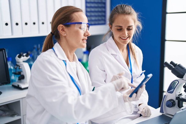 Dwie kobiety-naukowcy korzystające ze smartfona pracującego w laboratorium - Zdjęcie, obraz