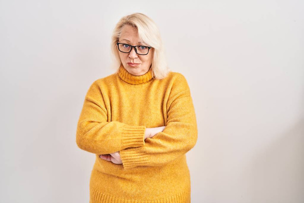 Middelbare leeftijd blanke vrouw het dragen van een bril staan over de achtergrond sceptisch en nerveus, afkeurende uitdrukking op het gezicht met gekruiste armen. negatieve persoon.  - Foto, afbeelding