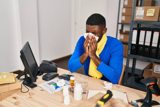 Young african american man ecommerce business worker using napkin at office - Foto, Bild