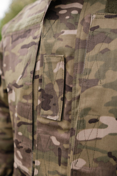 Preparazione al combattimento: primo piano del soldato che indossa l'ingranaggio sul campo - Foto, immagini