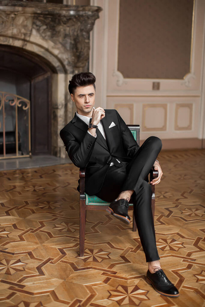 Jóképű férfi modell egy új öltönyben egy gyönyörű szobában. - Fotó, kép