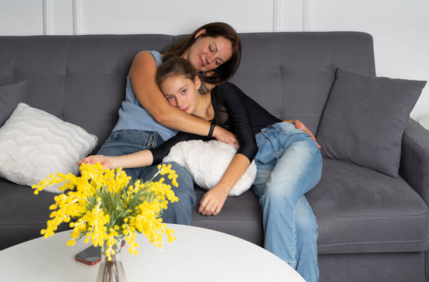 Happy family young beautiful mother and teen daughter having fun at home together - Фото, изображение