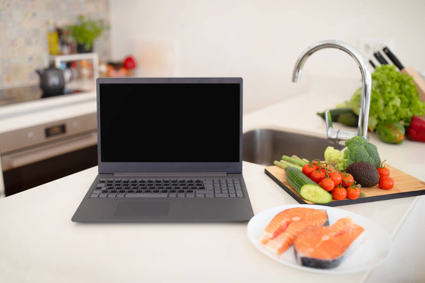 Online Recipes Inspiration. Laptop With Blank Screen Standing Near Healthy Fresh Grocery Products And Vegetables On A Kitchen Table Indoor. Food Blogging And Culinary Website Advertisement. Mockup - Photo, Image