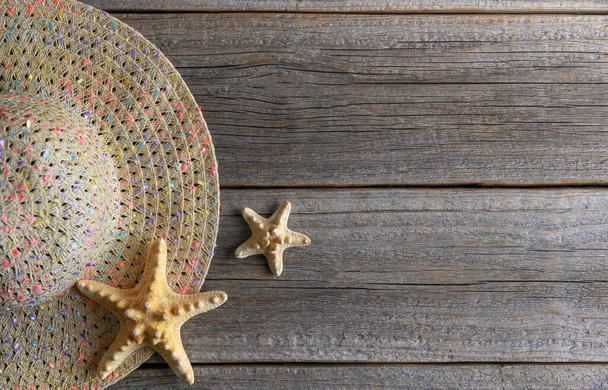 Hat and starfish on wooden boards. There is space for text. - Photo, image