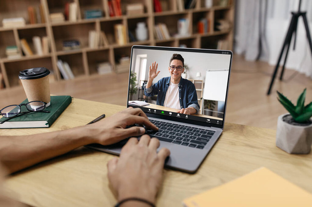 Unrecognizable man studying foreign language from home, having video chat with tutor, typing on keyboard while sitting at desk at home office, copy space for ad, collage - Photo, Image