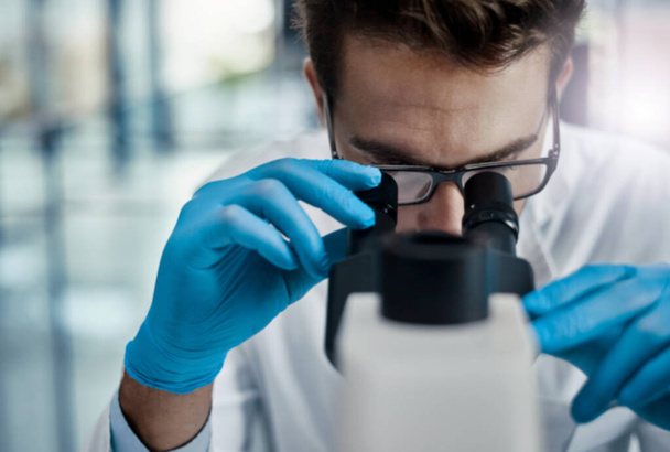 Наука створює можливості, щоб допомогти світу. молодий вчений-чоловік працює в лабораторії з мікроскопом
 - Фото, зображення