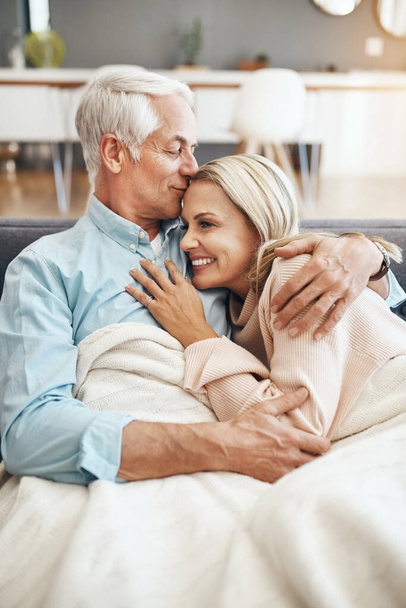 Never cold when Ive got you to hold. an affectionate mature couple relaxing on the sofa at home - Photo, Image