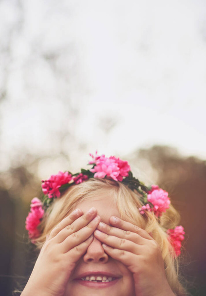 You cant see me. a cheerful little girl with her hands on her eyes playing hide and seek outside in nature - Zdjęcie, obraz
