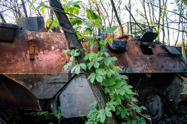 Un véhicule blindé BTR de l'armée ukrainienne a été détruit par des tirs d'artillerie dans la zone de combat près de Bahkmut, en bordure d'une forêt. Les armées russes et ukrainiennes se font face dans le Donbass, les combats sont intenses et les chars sont des cibles de choix. - Photo, image