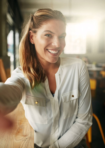 Selfie, smile and woman in a coffee shop, relax and cheerful with confidence, happiness and joyful. Portrait, female person and happy lady with social media, cafe and restaurant with beauty and break. - 写真・画像