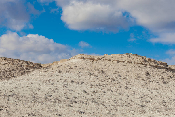 Limestone hill in front of cloudy blue sky. - Foto, Imagen