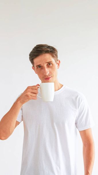 Morning coffee. Wake up habit. Confident pleased attractive man holding cup enjoying hot beverage isolated on white empty space background. - Φωτογραφία, εικόνα