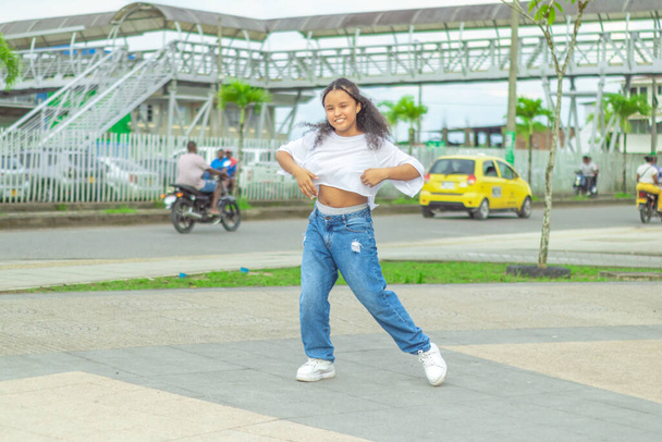 Nia de raices afrodescendientes baila al estilo urbano en el centro de la ciudad - Photo, Image