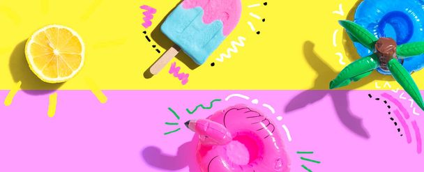 Summer concept with a flamingo float, lemon sunlight and a popsicle - flat lay - Fotó, kép
