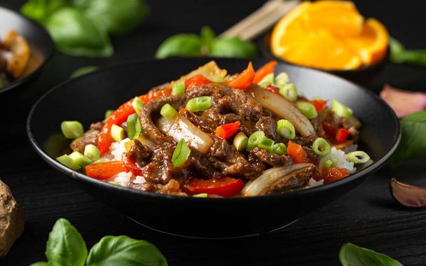 Knuspriges Orangenrindfleisch mit Paprika, Zwiebeln und Reis anbraten. Asiatische Lebensmittel. - Foto, Bild