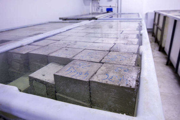 View of compressive strength test of concrete for cubic samples. Cubic or cylindrical samples of concrete are tested under a compression testing machine to measure this value. - Photo, Image