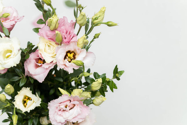Ein Bündel schöner Eustoma-Blumen auf neutralem Hintergrund - Foto, Bild