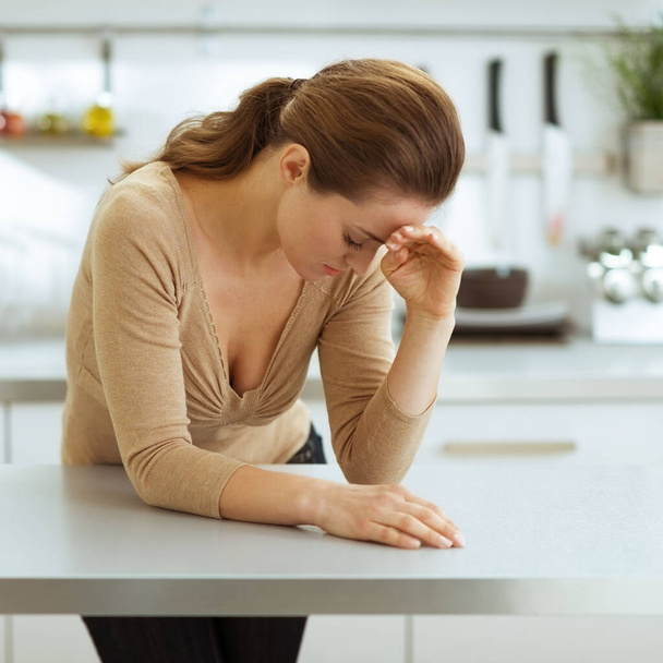Stressed young woman in kitchen - Fotoğraf, Görsel