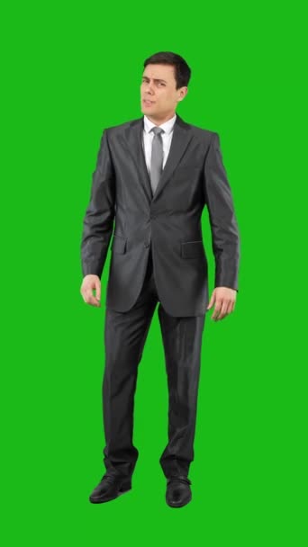 Ganzer Körper eines selbstbewussten Mannes im formalen Anzug, der auf Chroma-Schlüssel zeigt und in die Kamera schaut - Filmmaterial, Video