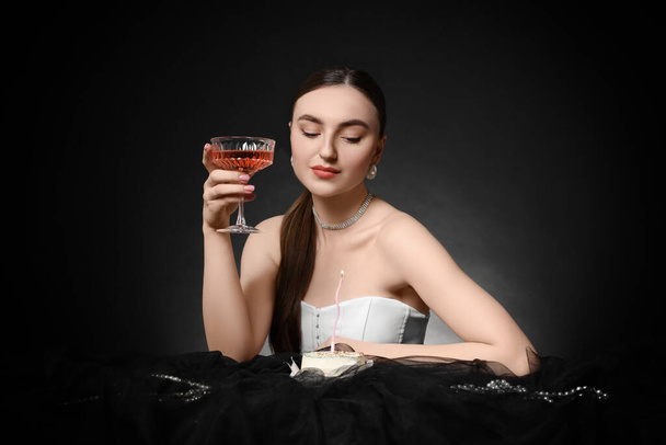Fashionable photo of attractive woman with glass of wine and her Birthday cake on black background - Zdjęcie, obraz