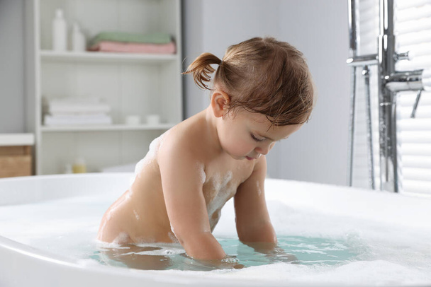 Cute little girl taking foamy bath at home - Zdjęcie, obraz