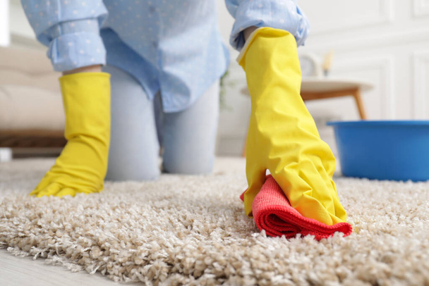Woman in rubber gloves cleaning carpet with rag indoors, closeup. Space for text - Valokuva, kuva