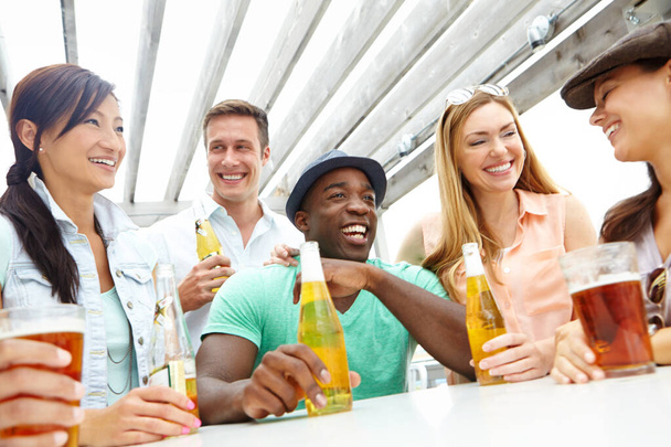 Weekend fun. A group of friends enjoying drinks on the deck of a trendy outdoors restaurant - Photo, Image