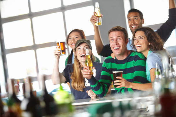 Katsoa urheilua paikallisessa juottolassa. Ystävät hurraavat suosikkijoukkueelle baarissa. - Valokuva, kuva