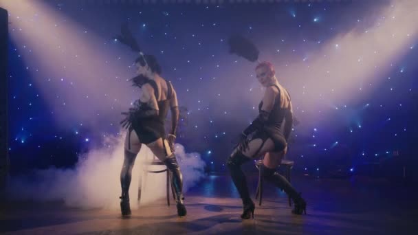 Deux femmes en sous-vêtements noirs se déplaçant sensuellement montrant les fesses, descendant vers le bas. Concept de cabaret 4K. Danseuses burlesques sexy séduisant client par la danse érotique sur scène de théâtre ou boîte de nuit  - Séquence, vidéo